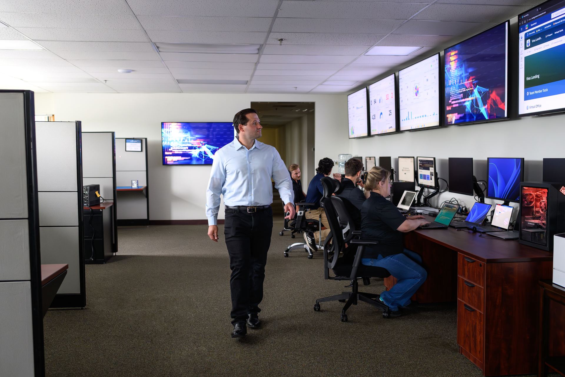 The Netlogic operations floor in Nashua, with engineers at their desks and monitoring dashboards along the wall