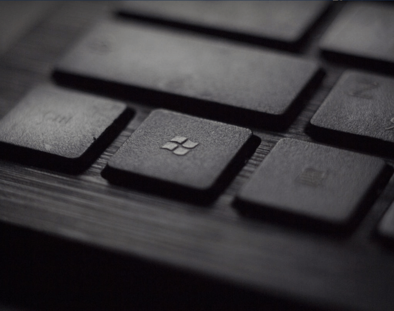 Close-up of a laptop keyboard featuring the Windows logo key, representing Microsoft operating system functionality