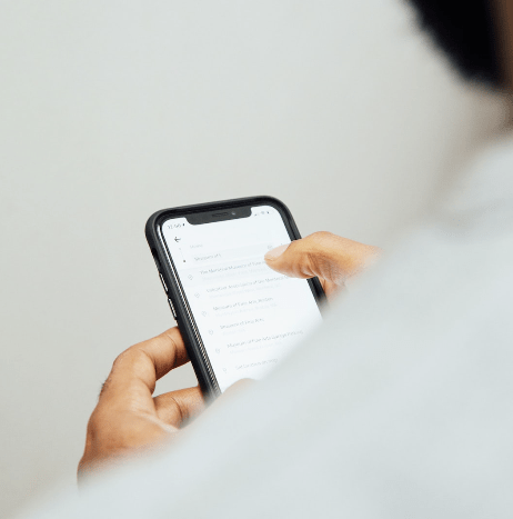 Person using a smartphone to read messages or notifications on a mobile app screen