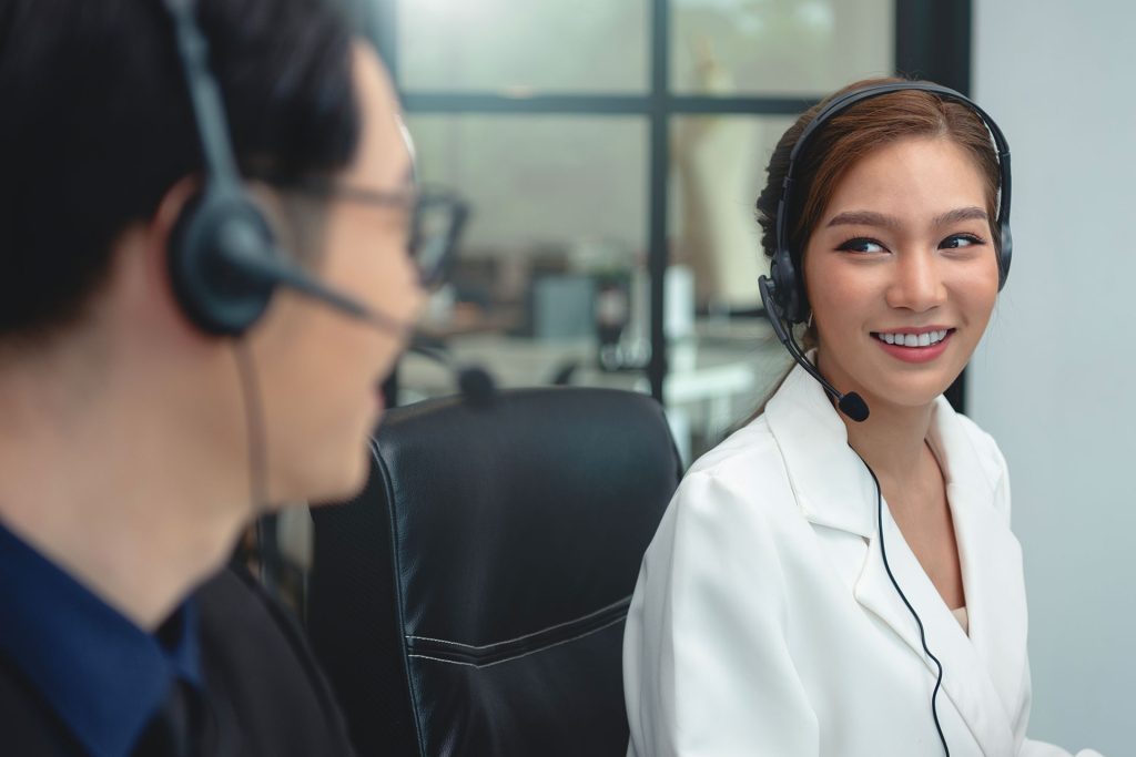 Customer support representatives wearing headsets collaborating in a modern office environment