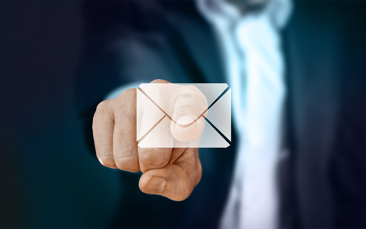 Business professional pointing toward a digital email icon representing contact or communication