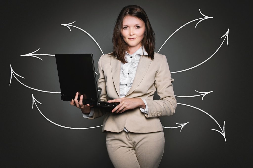 Business professional holding a laptop with arrows pointing outward in multiple directions
