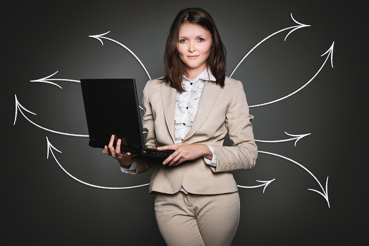 Business professional holding a laptop with arrows pointing outward in multiple directions