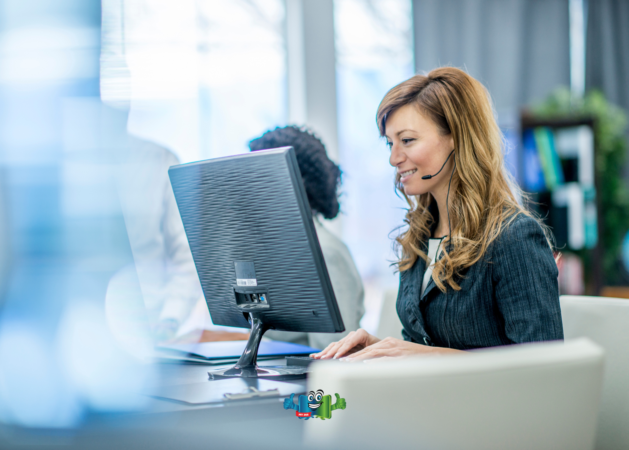 Customer support representative using a headset while working at a computer.
