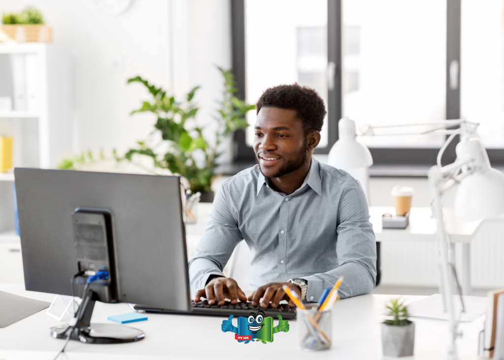 Man working at a desktop computer in a bright, modern office.